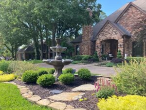 Residential landscaping by a professional landscape company in Grapevine, TX, featuring a manicured lawn and custom plant beds